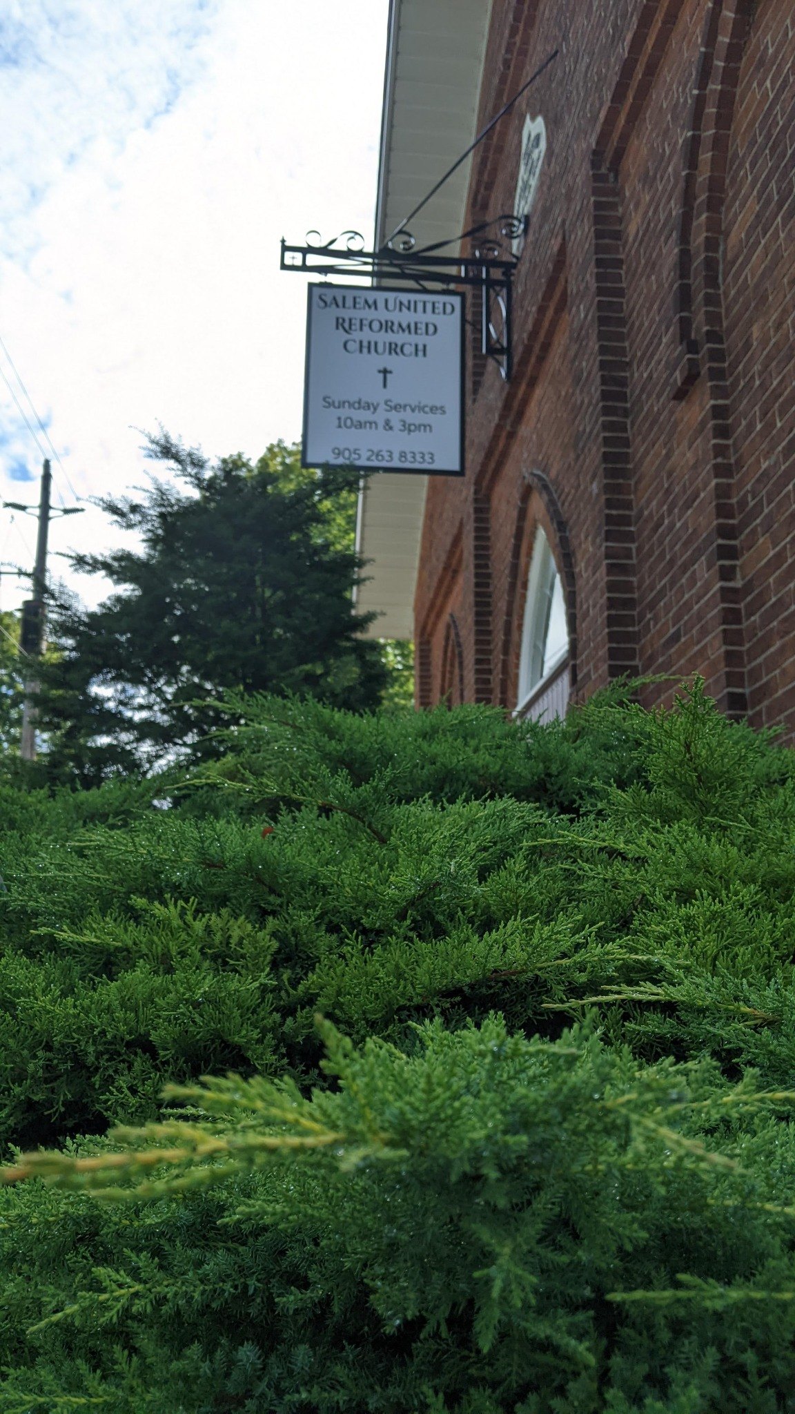 Salem United Reformed Church sign beside the brick church building