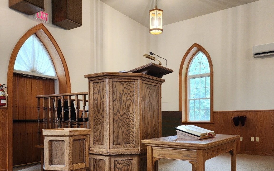Pulpit, baptismal font, communion table, and open Bible in the Salem sanctuary